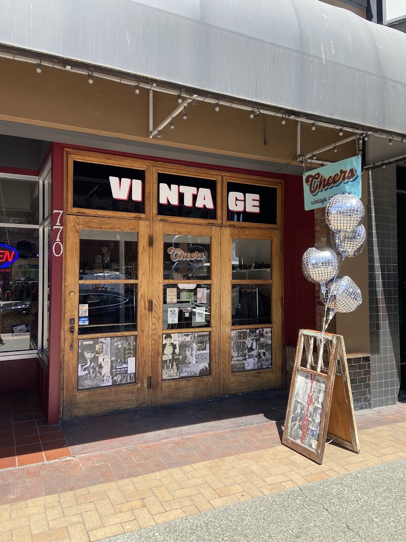 The Cheers Vintage Collective storefront on Yates Street: wooden doors with hand-lettered VINTAGE signage, a hanging Cheers shop sign, and disco-ball balloons out front.